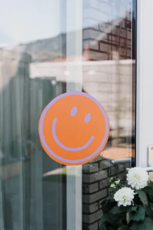 Sfeerbeeld Raamsticker D30, oranje smiley, vrolijke raamdecoratie, raamstickers kinderen en feest