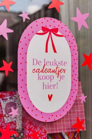 Decoratieve raamstickers rode en roze sterren voor feestelijke sfeer.