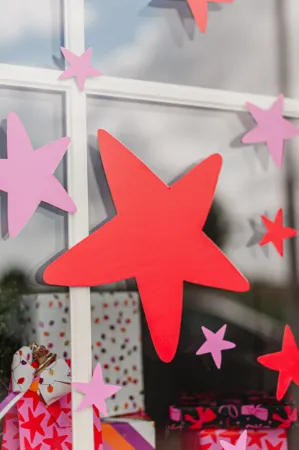 Raamsticker met grote rode en roze sterren voor feestelijke versiering.