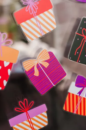 Verschillende gekleurde cadeautjes als raamsticker voor feestelijke gelegenheden.
